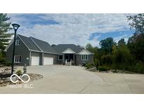 Gray house exterior with a three-car garage and circular driveway at 4270 Victoria Ln, Avon, IN 46123
