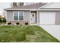 Gray siding two-car garage home with landscaping and a welcoming entrance at 1431 Coen Ct, Columbus, IN 47201