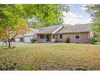 Brick ranch house with attached garage, porch, and green lawn at 7655 Westerville Dr, Clayton, IN 46118