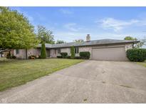 Brick ranch home with attached garage and landscaped lawn at 1061 Saint Paul St, Shelbyville, IN 46176