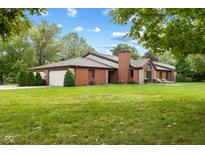 Brick ranch home with attached two-car garage and lush green lawn at 9263 Golden Oaks W, Indianapolis, IN 46260