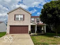 Two-story house with a brown garage door and landscaped lawn at 6840 Minnow Dr, Indianapolis, IN 46237