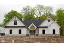 Farmhouse style home with white siding and stone accents at 3657 Sycamore Bend S Way, Columbus, IN 47203