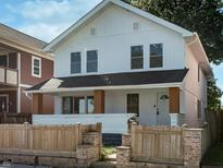Charming two-story home with white siding, brown accents, and a wood fence at 2442 Guilford Ave, Indianapolis, IN 46205