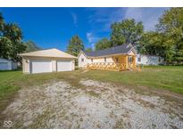 House exterior showcasing a two-car garage and wooden deck at 2682 E 150 S, Anderson, IN 46017