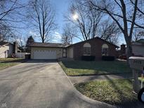 Brick ranch home with attached garage and mature trees at 3415 Forsythia Dr, Columbus, IN 47203