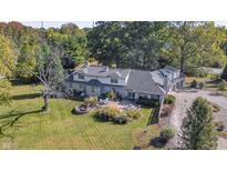 Stone house with patio, firepit, and large backyard. Triple car garage and basketball court at 6502 Allisonville Rd, Indianapolis, IN 46220