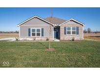 Gray and brick one-story home with a landscaped lawn and blue door at 7920 Magnolia St, New Palestine, IN 46163