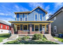 Blue and yellow two-story house with a brick porch at 1007 Broadway St, Indianapolis, IN 46202