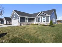 Gray siding two-car garage and stone accents characterize this charming craftsman style home at 432 Charles Freer Ln, Whiteland, IN 46184