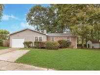 Single story home with attached garage and landscaped yard at 4828 Tempe Ct, Indianapolis, IN 46241
