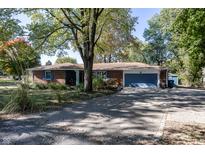 Brick ranch house with attached garage and driveway at 7060 S Meridian St, Indianapolis, IN 46217