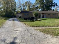 Ranch-style home with attached garage and landscaped yard at 647 W Mcgregor Rd, Indianapolis, IN 46217