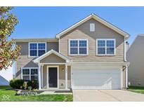 Two-story house with beige siding, white garage door and landscaping at 4633 Angelica Dr, Indianapolis, IN 46237