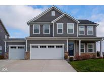 Two-story gray house with white garage doors and stone accents at 16703 Ayshire Dr, Fishers, IN 46037