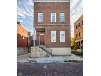 Brick three-story home with steps leading to the entrance at 711 N Cleveland St, Indianapolis, IN 46202