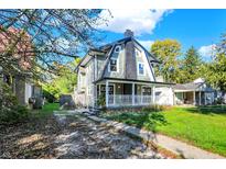 Two-story home with gray siding, white porch, and landscaped lawn at 3616 N College Ave, Indianapolis, IN 46205