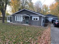 Gray house with a green door and surrounding trees at 121 West St, Pendleton, IN 46064