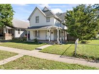 Two-story home with a front porch and fenced yard at 335 N Grant Ave, Indianapolis, IN 46201