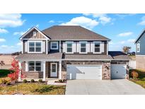 Two-story house with brick and stone exterior, two-car garage, and landscaped yard at 66 N Sedona Dr, Bargersville, IN 46106