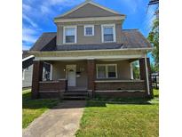 Two-story house with brick facade and a front porch at 709 W Riverside Ave, Muncie, IN 47303