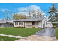 Ranch home with a paved driveway and landscaping at 325 S Kenmore Rd, Indianapolis, IN 46219