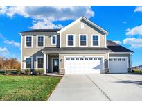 Two-story house with taupe siding, white trim, and a three-car garage at 5856 Fair Oak Cir, Brownsburg, IN 46112