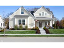 Two-story farmhouse with beige siding, gray roof, and landscaped lawn at 14289 Mccormick Cir, Carmel, IN 46033