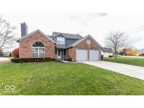 Brick house with two-car garage and landscaped lawn at 11155 Baywood Ln, Indianapolis, IN 46236