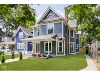 Charming blue two-story home with a landscaped lawn and walkway at 408 W 11Th St, Anderson, IN 46016