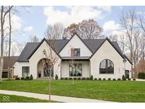 White brick home with black trim, a gabled roof, and a manicured lawn at 10771 Holliday Farms Blvd, Zionsville, IN 46077
