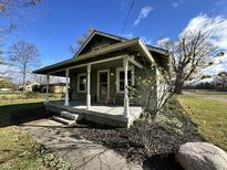 Charming one-story home with front porch and rocking chairs at 5719 Hickory Rd, Indianapolis, IN 46239