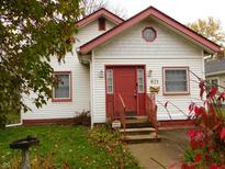 Charming single story home with red accents and a well-maintained lawn at 821 N Tuxedo St, Indianapolis, IN 46201