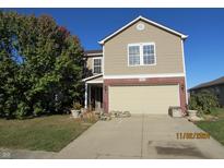 Two-story house with a beige exterior, brick accents, and a two-car garage at 940 Shenandoah Way, Greenwood, IN 46143