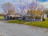 Gray house with carport and mature trees in the front yard at 943 N 12Th St, Elwood, IN 46036