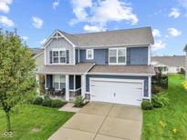 Two-story home with gray and blue siding, a white garage door, and a landscaped front yard at 1285 Greenwood Station Blvd, Greenwood, IN 46143