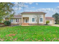 House exterior with stone and siding, a brown roof, and a manicured lawn at 5909 Buttonwood Dr, Noblesville, IN 46062