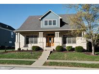 Beautiful two-story home with brick and siding, a covered porch and landscaping at 7290 Lockford Walk N, Avon, IN 46123