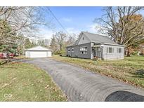 Gray house with attached garage and a long driveway at 8240 Shelbyville Rd, Indianapolis, IN 46259