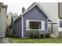 Side view of a charming blue bungalow with landscaping at 907 S East St, Indianapolis, IN 46225