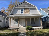 Two-story house with gray siding, a covered porch, and a gabled roof at 1210 N Rural St, Indianapolis, IN 46201