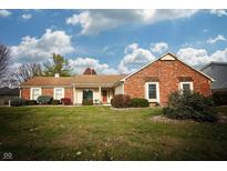 Brick ranch house with attached garage, landscaping, and a large yard at 12737 Wembly Rd, Carmel, IN 46033