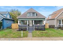 Charming green house with gray accents, a porch, and a well-maintained lawn at 1542 S Alabama St, Indianapolis, IN 46225