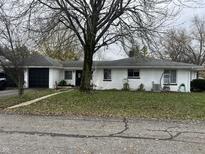 Charming ranch home with white brick exterior, two-car garage, and mature landscaping at 315 S Main St, Wilkinson, IN 46186