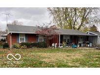 Brick ranch house with covered porch and mature trees at 705 Wilson St, Greenfield, IN 46140