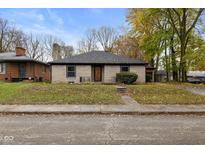 Brick ranch house with a landscaped lawn and driveway at 3805 Byram Ave, Indianapolis, IN 46208
