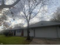 Brick ranch home with attached garage and landscaped lawn at 3936 Delmont Dr, Indianapolis, IN 46235