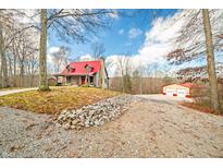 Log cabin home with red metal roof, porch, and detached garage at 6465 Mt Moriah Rd, Nineveh, IN 46164
