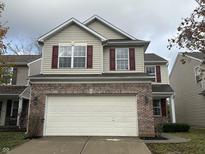 Two-story house with tan siding, brick bottom, and a two-car garage at 3518 Birchfield Pl, Indianapolis, IN 46268