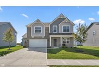 Two-story brick home with gray accents, a white garage door, and a landscaped lawn at 10797 Walden Ln, Brownsburg, IN 46112
